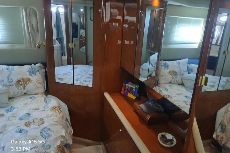 Slide: The Image of Luxurious 2000 Sea Ray 420 Aft Cabin interior with elegant wood finishes and cozy bedding. - 8