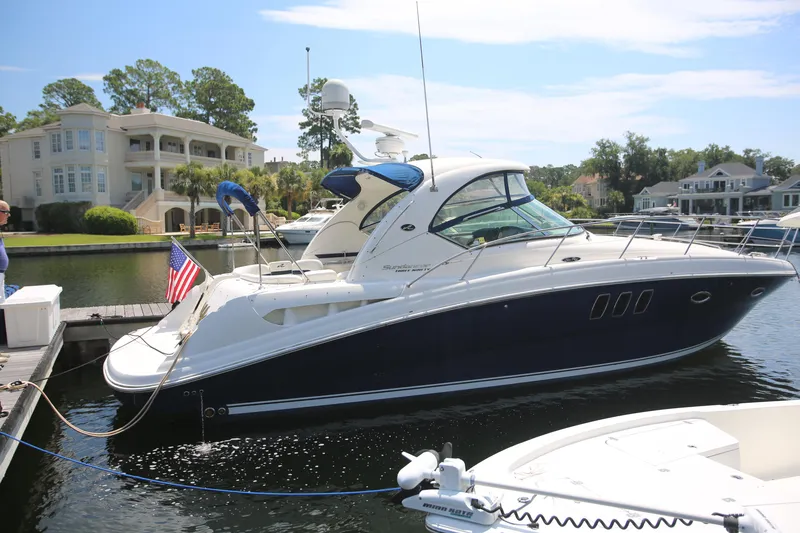 Slide: The Image of 2010 Sea Ray 390 Sundancer yacht docked at marina with American flag. - 2