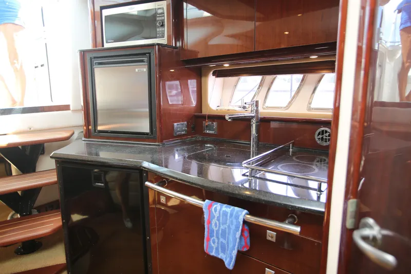 Slide: The Image of Luxurious kitchen area in a 2010 Sea Ray 390 Sundancer yacht, featuring modern appliances. - 20