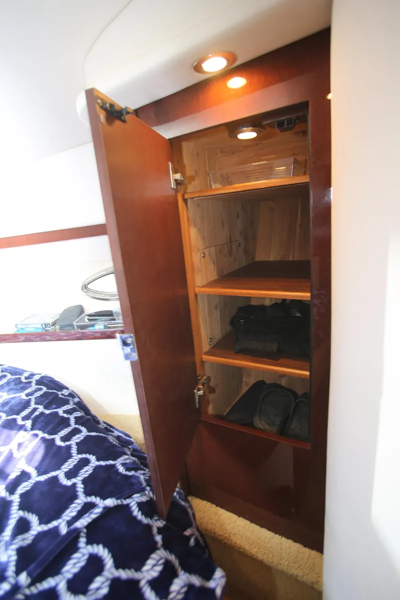 Slide: The Image of 2010 Sea Ray 390 Sundancer cabin with open wooden closet and shelves. - 23