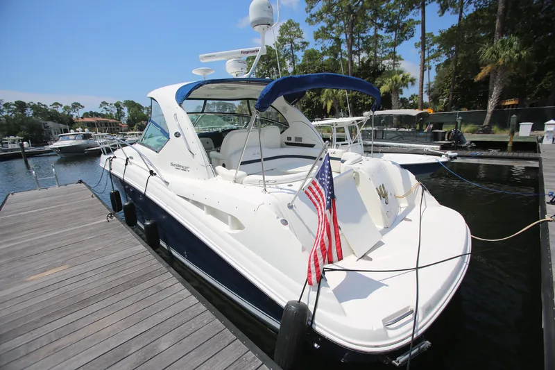 Slide: The Image of 2010 Sea Ray 390 Sundancer docked, featuring sleek design and American flag. - 8