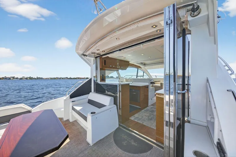 Slide: The Image of 2020 Cruisers Yachts 50 Cantius, luxurious interior with open deck, overlooking serene waters. - 14