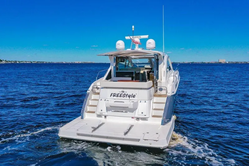 Slide: The Image of 2020 Cruisers Yachts 50 Cantius on open water, rear view, clear blue sky. - 5