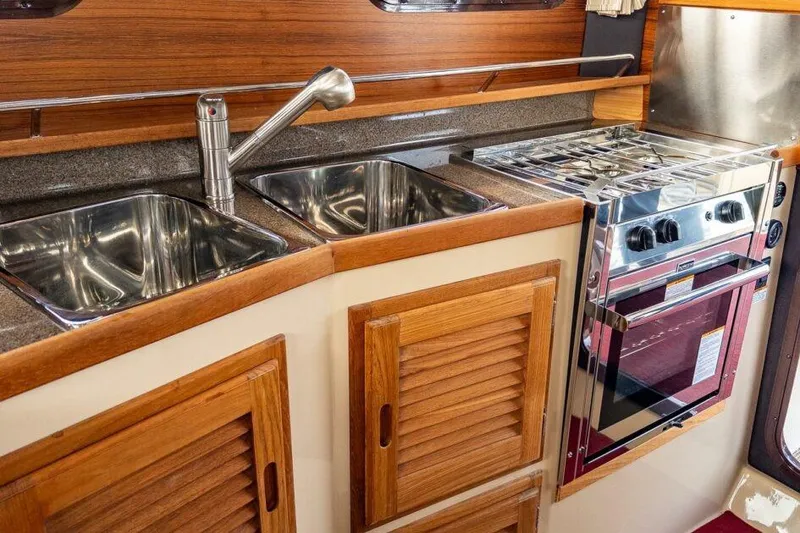 Slide: The Image of 2019 Ranger Tugs R-31-S galley with dual sinks and stainless steel stove. - 16