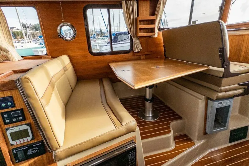 Slide: The Image of Interior of 2019 Ranger Tugs R-31-S with beige seating and wooden table. - 21