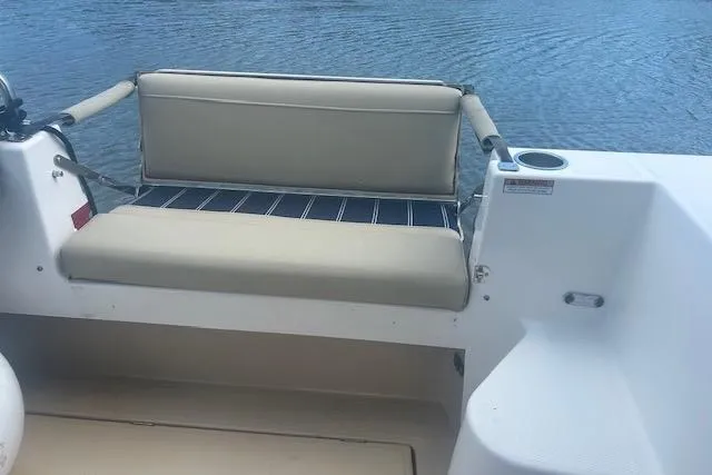 Slide: The Image of 2019 Ranger Tugs R-31-S boat with beige seating, cup holder, and water view. - 9
