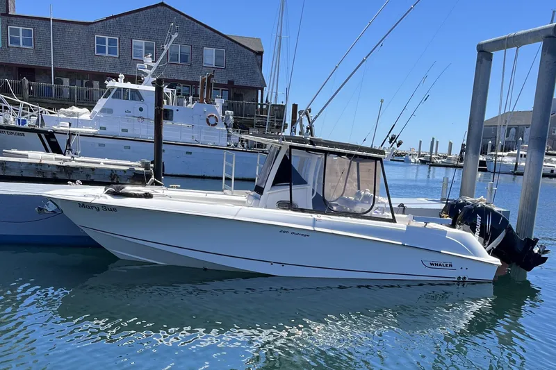 The Image of 2014 Boston Whaler 280 Outrage boat docked in a marina under clear blue skies. - 0