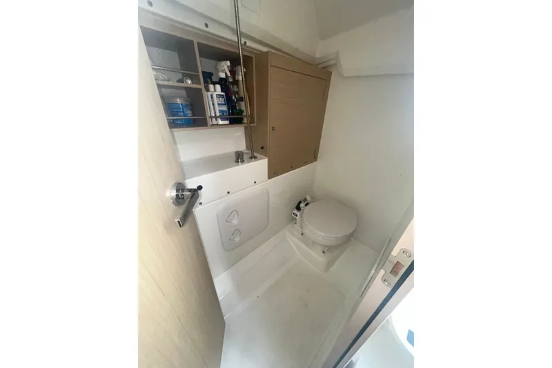 Slide: The Image of Beneteau Oceanis 30.1 2020 yacht bathroom with toilet and storage shelves. - 11