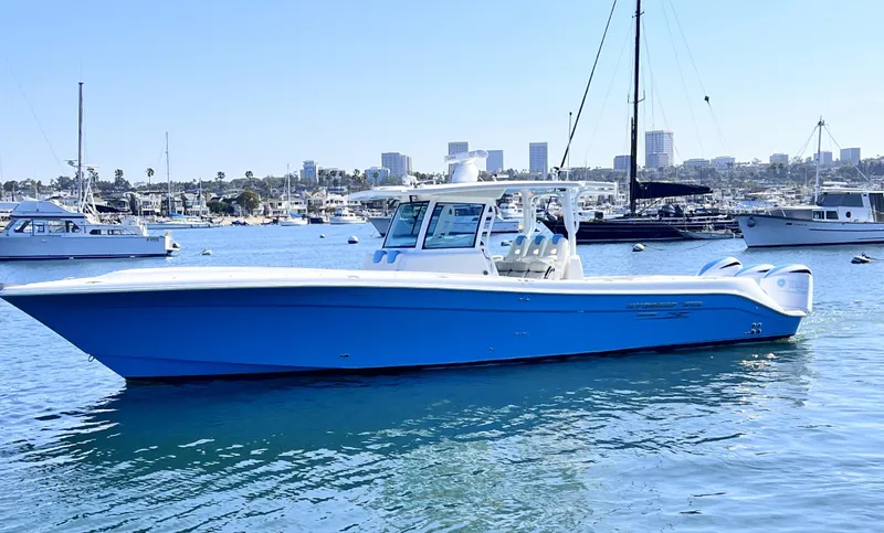 Slide: The Image of 2018 HCB 39 Speciale boat on calm water with city skyline in background. - 2