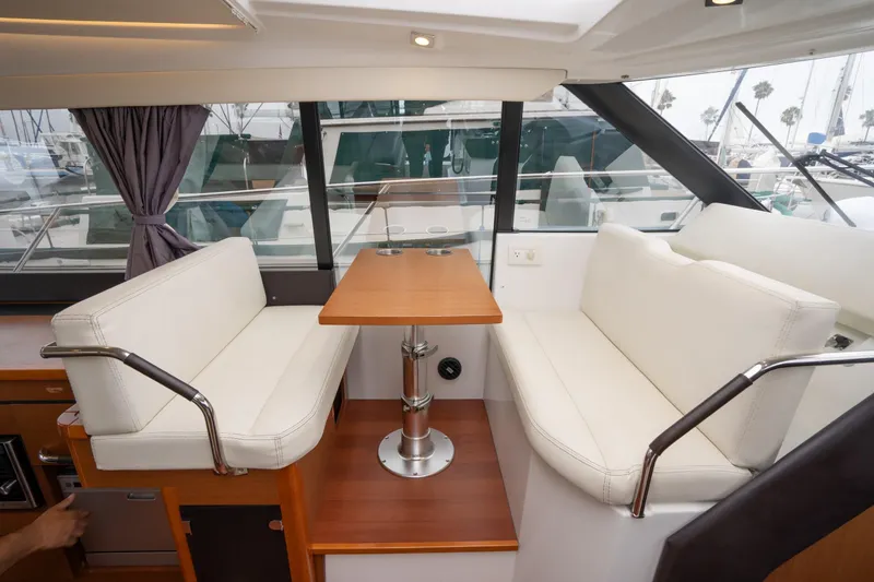 Slide: The Image of Interior of 2014 Jeanneau NC 14 yacht with white seating and wooden table. - 21