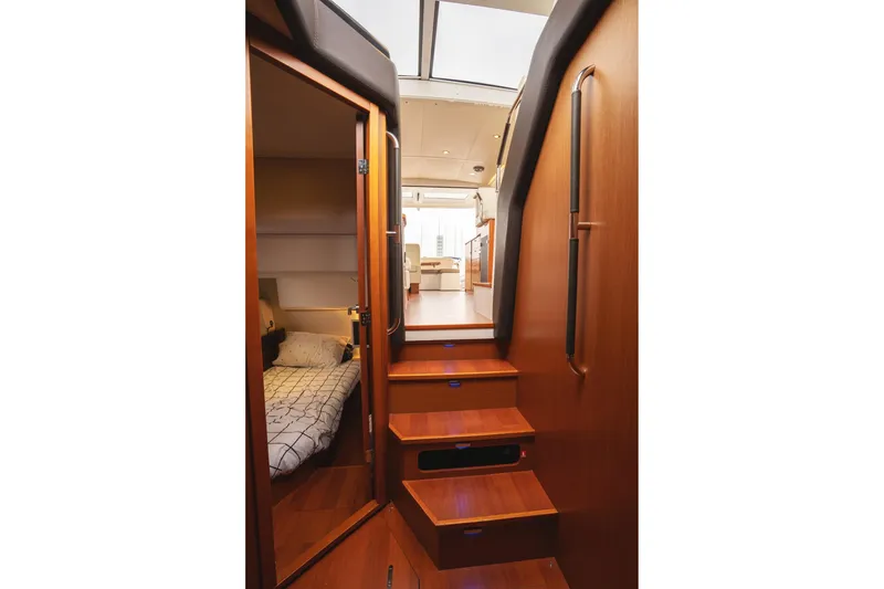 Slide: The Image of Interior of 2014 Jeanneau NC 14 yacht, featuring wooden stairs and cozy cabin. - 31