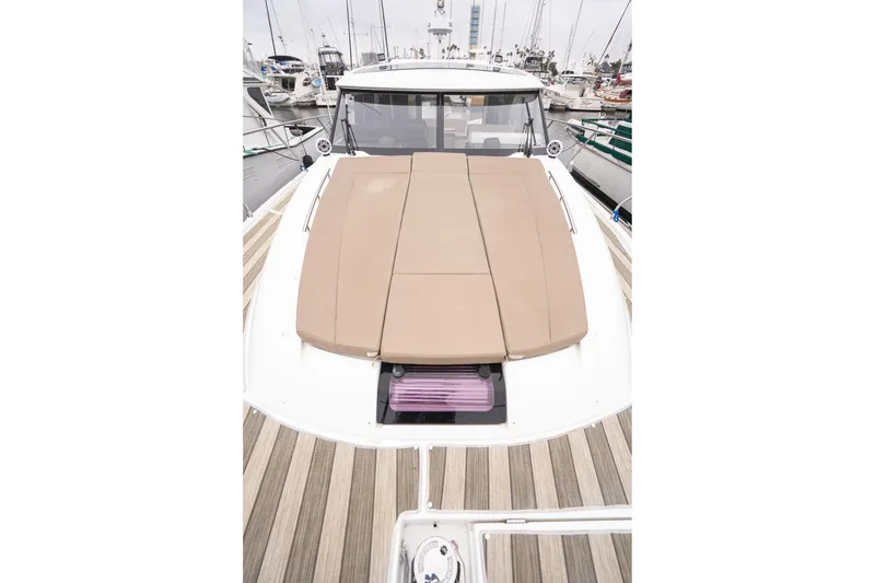 Slide: The Image of 2014 Jeanneau NC 14 yacht with cushioned deck, docked in marina. - 46