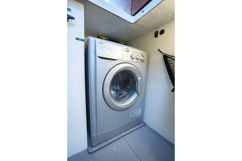 Slide: The Image of Washing machine inside 2014 Jeanneau NC 14 boat, compact laundry area. - 57