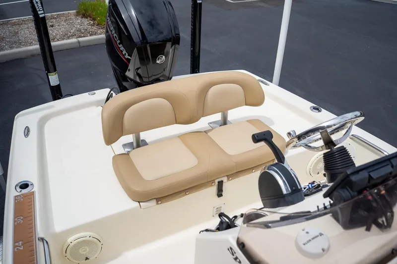 Slide: The Image of 2019 Scout 177 Sportfish Flats boat interior with beige seating and Mercury engine. - 11