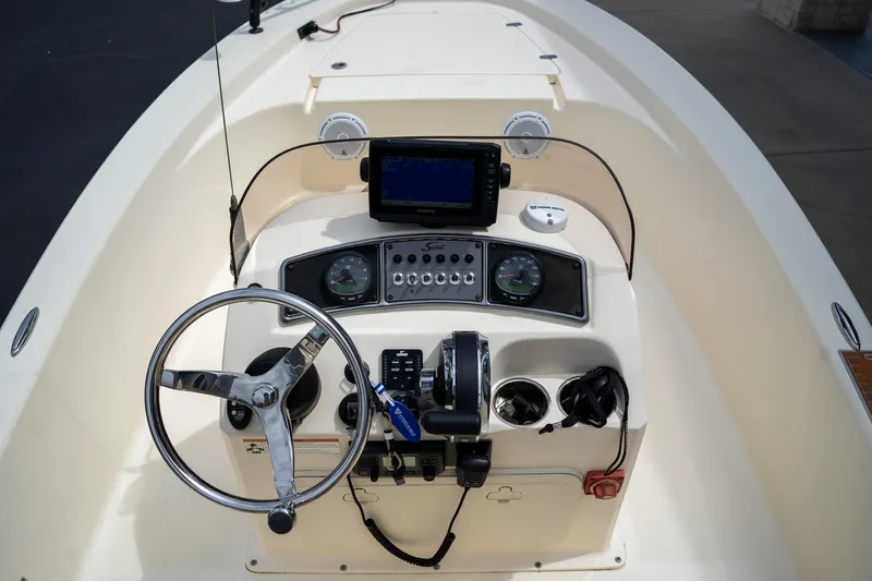 Slide: The Image of 2019 Scout 177 Sportfish Flats boat dashboard with steering wheel and navigation controls. - 22