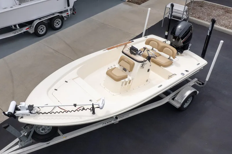 Slide: The Image of 2019 Scout 177 Sportfish Flats boat on trailer, featuring beige seating and outboard motor. - 4