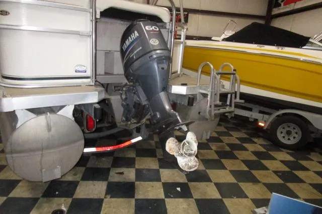 Slide: The Image of 2005 Harris FloteBote Cruiser 240 with Yamaha 60 outboard motor in a garage. - 4