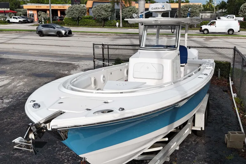 Slide: The Image of 2015 Edgewater 320CC boat on trailer, featuring a sleek design and Garmin equipment. - 2