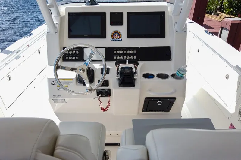 Slide: The Image of Cockpit of 2015 Edgewater 320CC boat with steering wheel and control panel. - 7