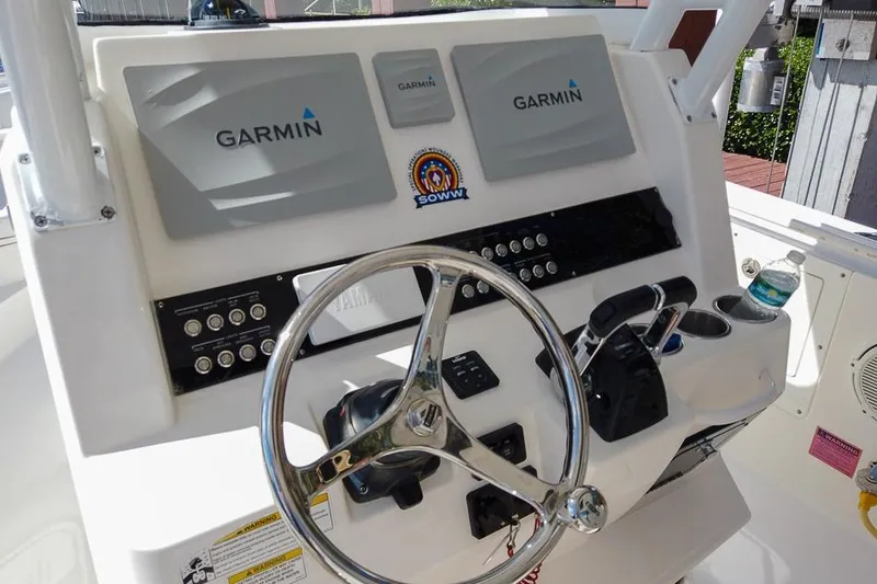 Slide: The Image of Edgewater 320CC 2015 boat dashboard with Garmin displays and steering wheel. - 8