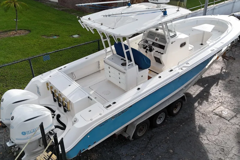 Slide: The Image of 2015 Edgewater 320CC boat with dual Yamaha engines on a trailer. - 9