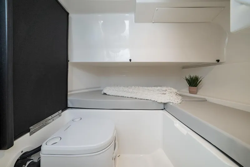 Slide: The Image of Manufacturer Provided Image: 2024 Sea Ray SDX 250 boat interior cabin with toilet and seating area. - 11