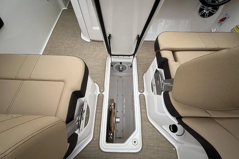 Slide: The Image of 2024 Sea Ray SDX 250 interior storage compartment with beige seating and carpeted flooring. - 18