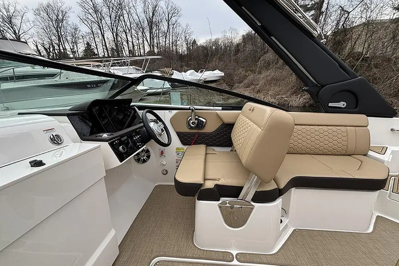 Slide: The Image of 2024 Sea Ray SDX 250 boat interior with beige seating and modern dashboard. - 19