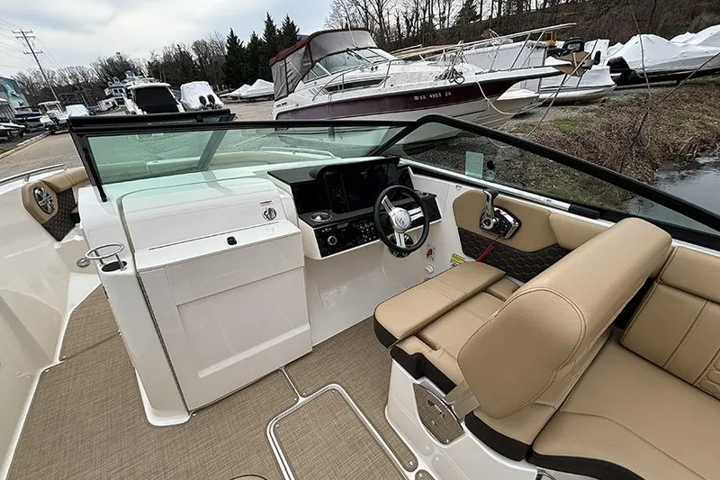Slide: The Image of 2024 Sea Ray SDX 250 boat interior with beige seating and modern dashboard. - 20