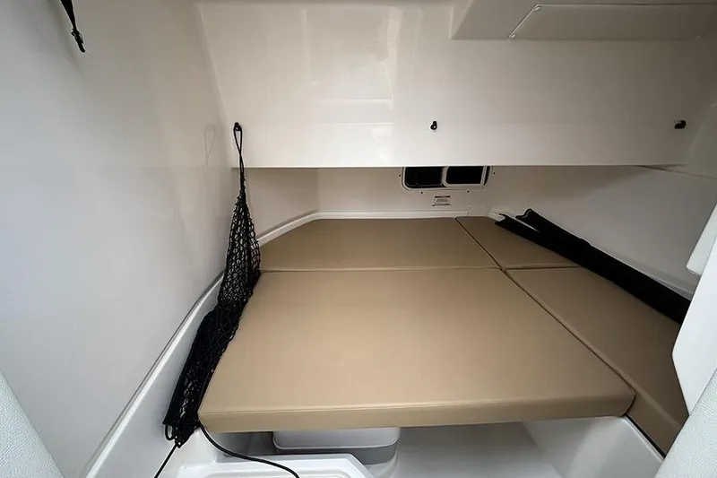 Slide: The Image of 2024 Sea Ray SDX 250 cabin interior with beige cushions and storage net. - 24