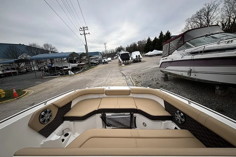 Slide: The Image of 2024 Sea Ray SDX 250 boat interior with tan seating at a marina. - 26
