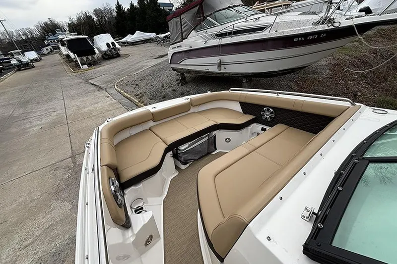 Slide: The Image of 2024 Sea Ray SDX 250 boat with spacious tan seating in a marina setting. - 27