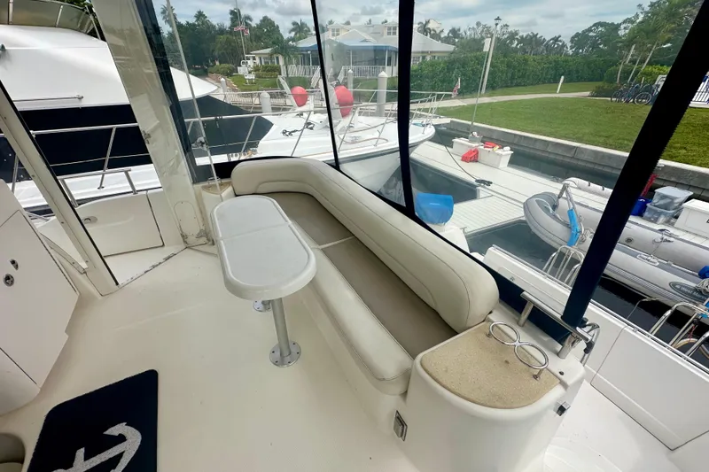 Slide: The Image of 2005 Meridian 459 Motoryacht interior with seating area and table, docked at marina. - 10