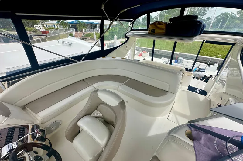 Slide: The Image of 2005 Meridian 459 Motoryacht interior with plush seating and helm, docked at marina. - 16