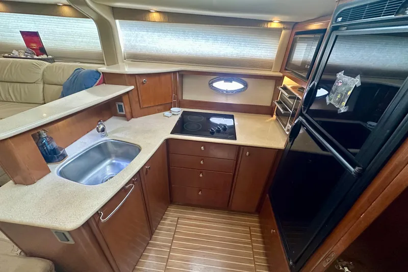 Slide: The Image of 2005 Meridian 459 Motoryacht kitchen with modern appliances and wooden cabinetry. - 23