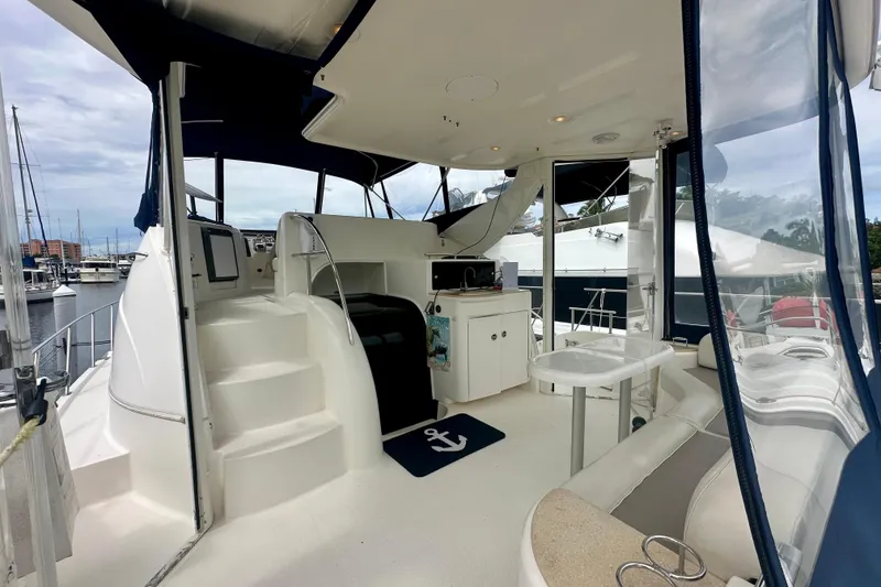 Slide: The Image of 2005 Meridian 459 Motoryacht interior with seating, table, and helm station in marina setting. - 9