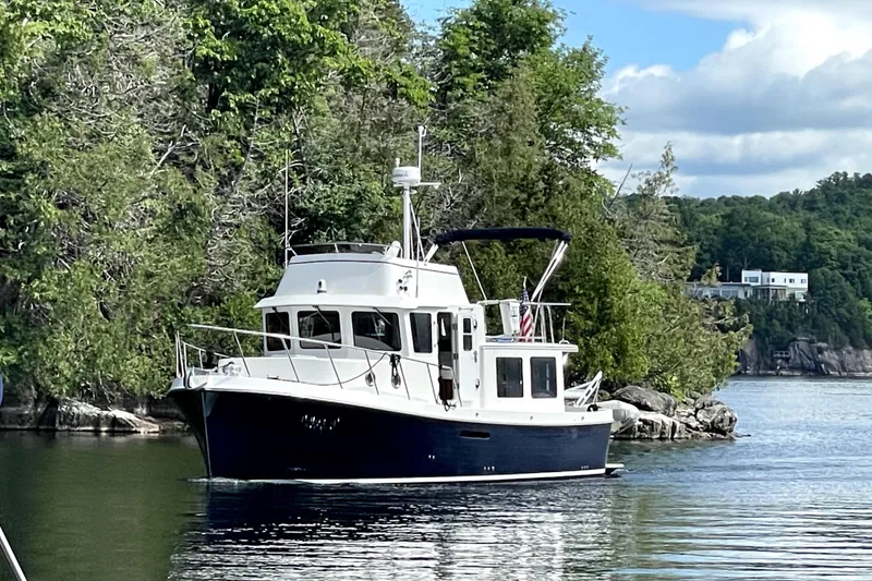 Slide: The Image of 2007 American Tug 34 cruising on a scenic, tree-lined waterway. - 1