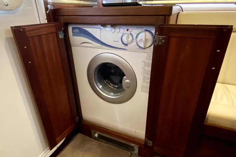 Slide: The Image of Built-in washing machine on a 2007 American Tug 34 boat, with wooden cabinet doors open. - 12