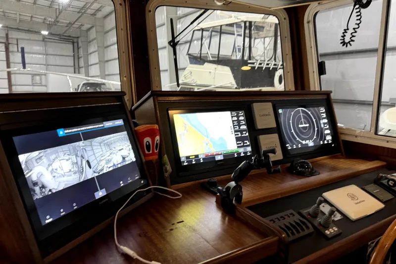 Slide: The Image of American Tug 34 (2007) helm with navigation screens and controls in a boatyard. - 17