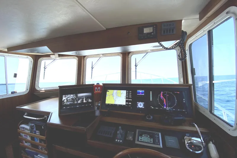 Slide: The Image of Pilothouse interior of 2007 American Tug 34, featuring navigation equipment and ocean view. - 18