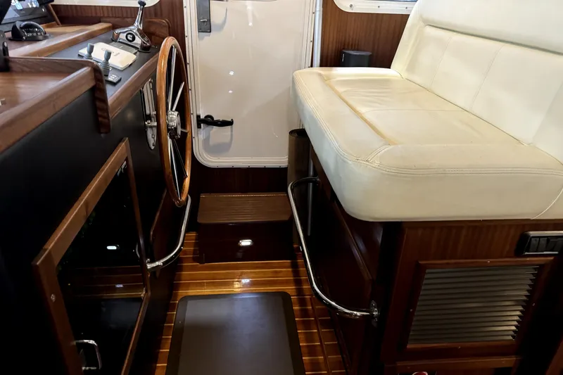 Slide: The Image of Interior of 2007 American Tug 34, featuring helm station and cushioned seating. - 19