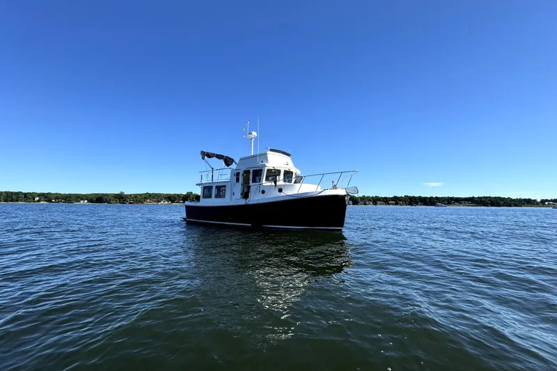 Slide: The Image of 2007 American Tug 34 boat on calm water under clear blue sky. - 2