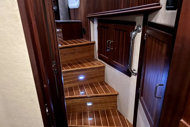 Slide: The Image of Staircase with wooden steps and LED lights inside a 2007 American Tug 34 boat. - 24