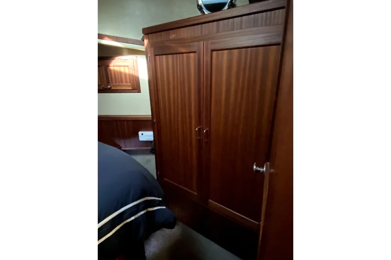 Slide: The Image of Interior of 2007 American Tug 34, featuring wooden cabinetry and cozy bedroom space. - 26