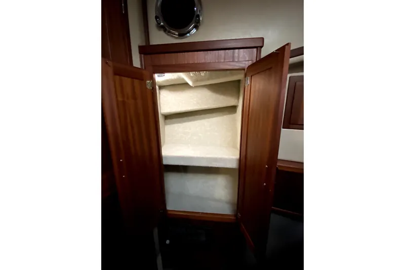 Slide: The Image of Open wooden cabinet with shelves inside a 2007 American Tug 34 boat. - 32