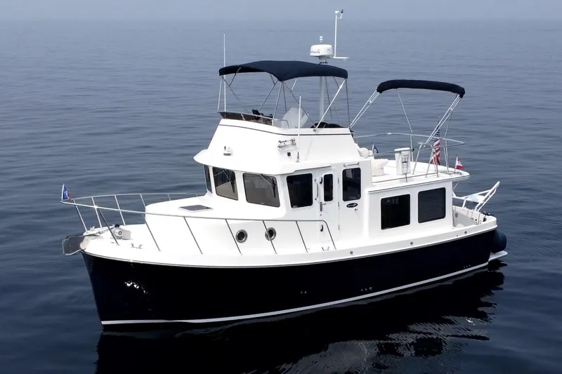 Slide: The Image of 2007 American Tug 34 cruising on calm waters, featuring a sleek design and spacious deck. - 36
