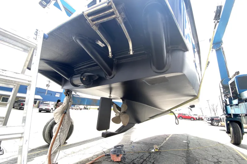 Slide: The Image of 2007 American Tug 34 being lifted, showing underside and propeller in a boatyard. - 38