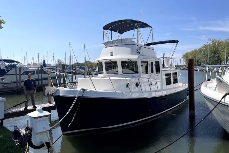 Slide: The Image of 2007 American Tug 34 docked at marina under clear blue sky. - 5
