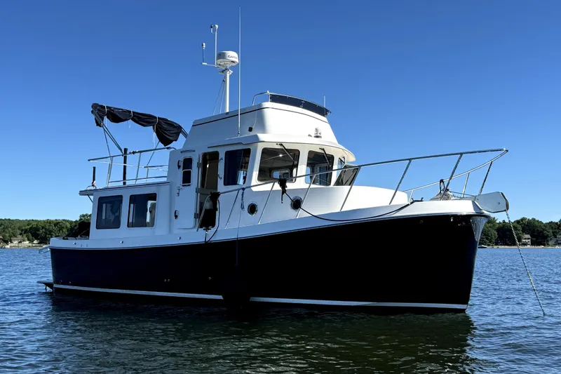 Slide: The Image of 2007 American Tug 34 boat on calm water under clear blue sky. - 6