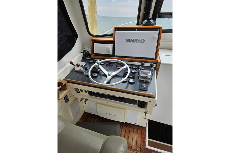 Slide: The Image of 1976 Harris boat helm with Simrad navigation system and steering wheel. - 2